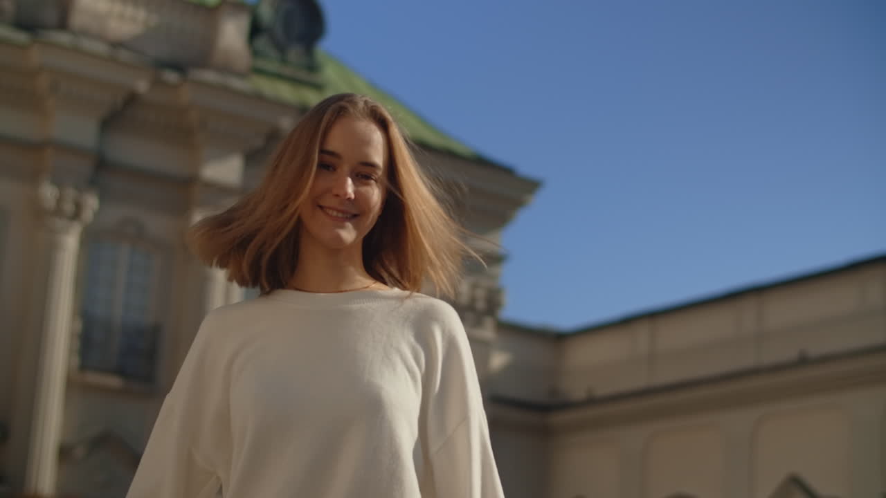 Young Woman Walking in Front of a Palace