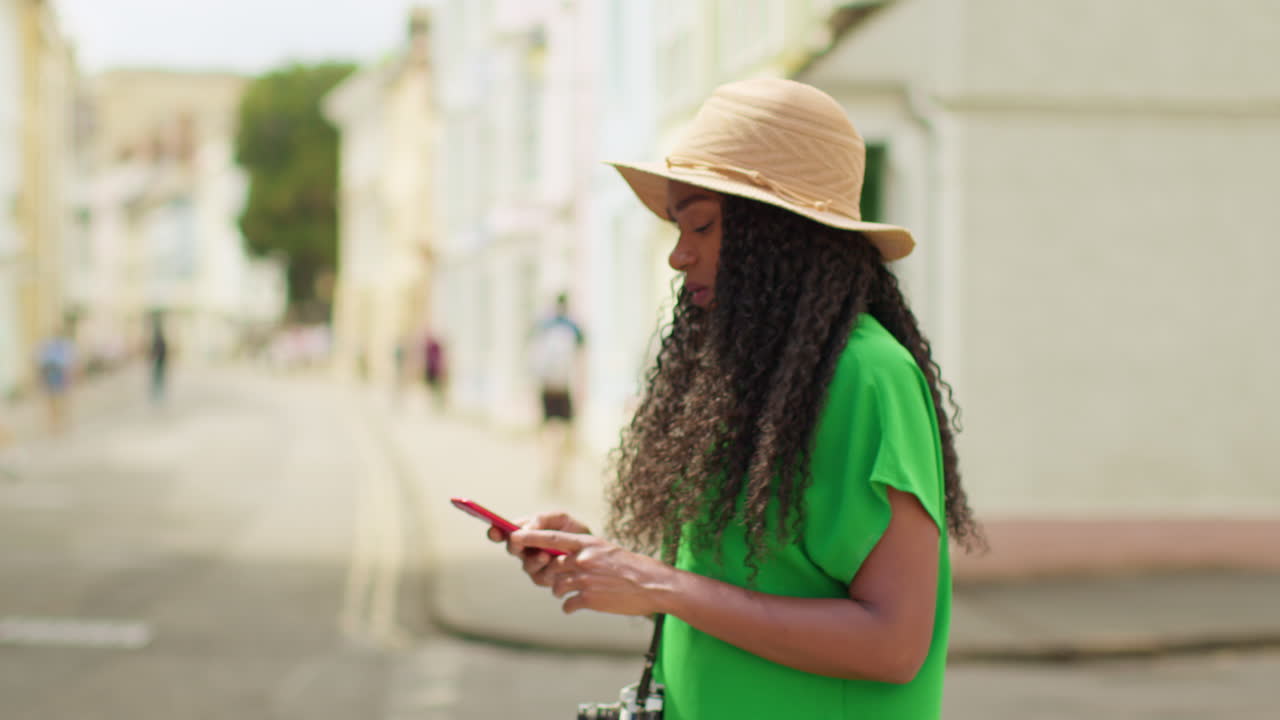 Female Tourist With Camera On Vacation In Oxford UK Exploring City Walking Along Holywell Street Using Mobile Phone For Directions And Information