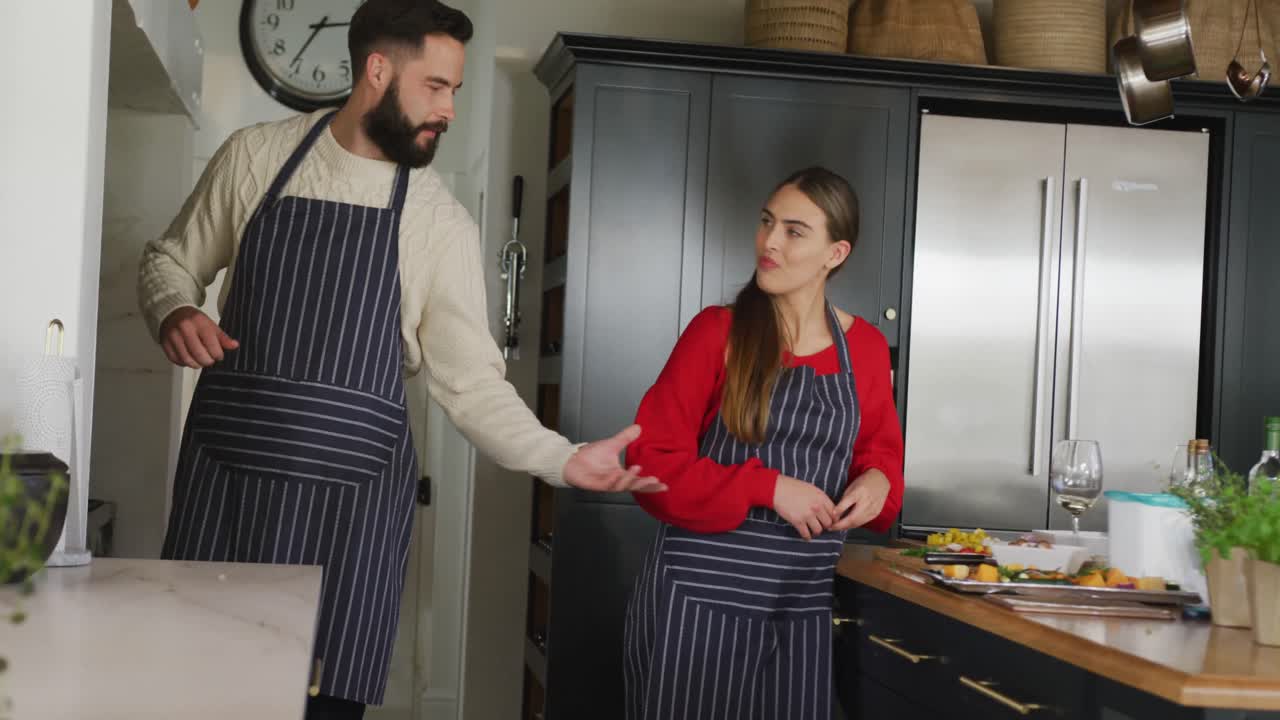 video de una feliz pareja caucásica pelando verduras en la cocina