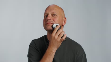 man shaving with electric razor