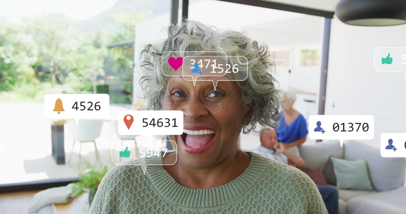 Senior woman talking to cam in home causing social likes floating around face rising fading smiling