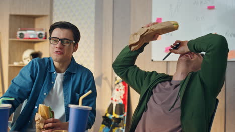 positive men looking monitor eating sandwiches at office closeup. lunch break