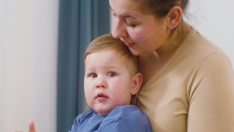 close up of a baby boy clapping hands and playing with his mom at home