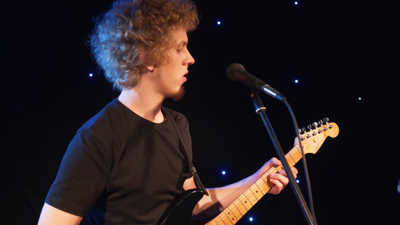 banda de rock de concierto actuando en el escenario con dos guitarras eléctricas cantantes. video musical punk, heavy metal o grupo de rock. banda de instrumentos de cámara lenta de dos hombres