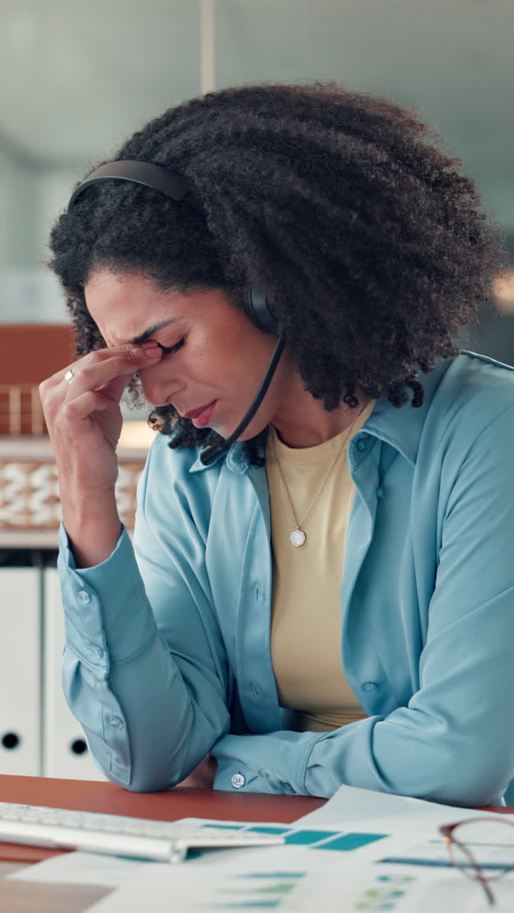 Donna stressata con cuffie alle prese con il burnout alla scrivania dell'ufficio