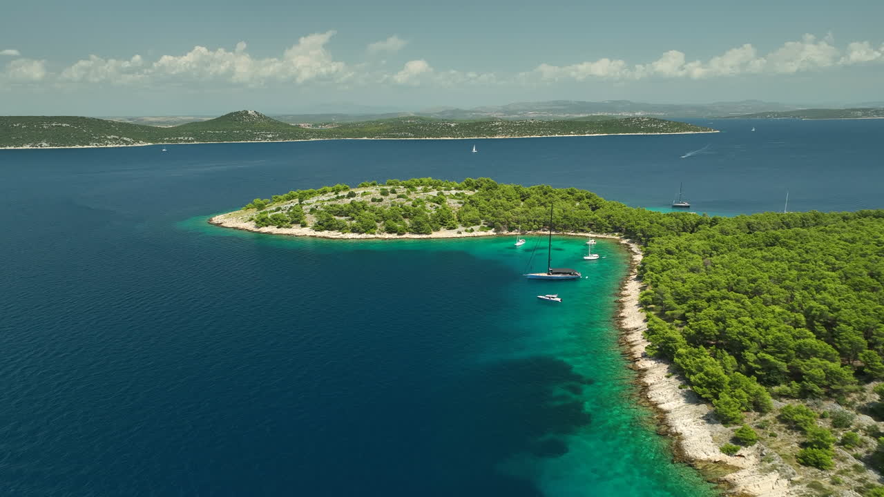 Luxury yachts moored in a shallow bay at Zmajan island on a sunny day