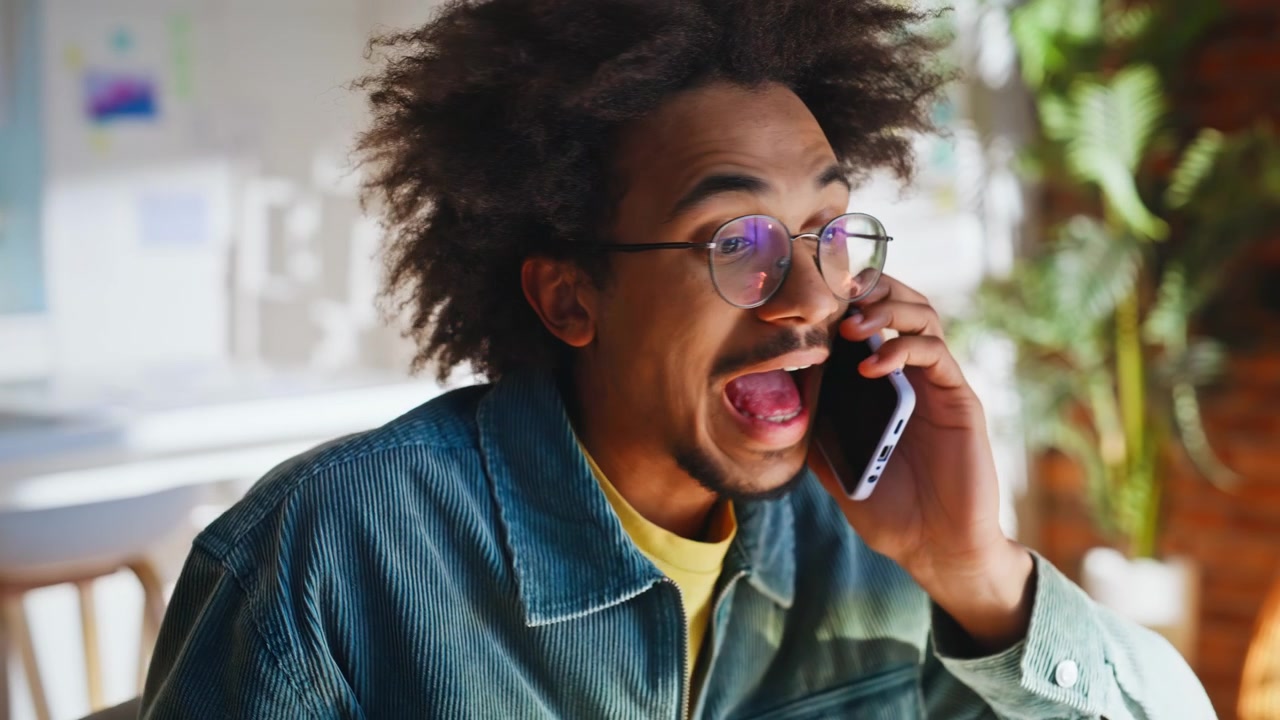 Multiracial creative talking mobile phone office. Closeup surprised man smiling.