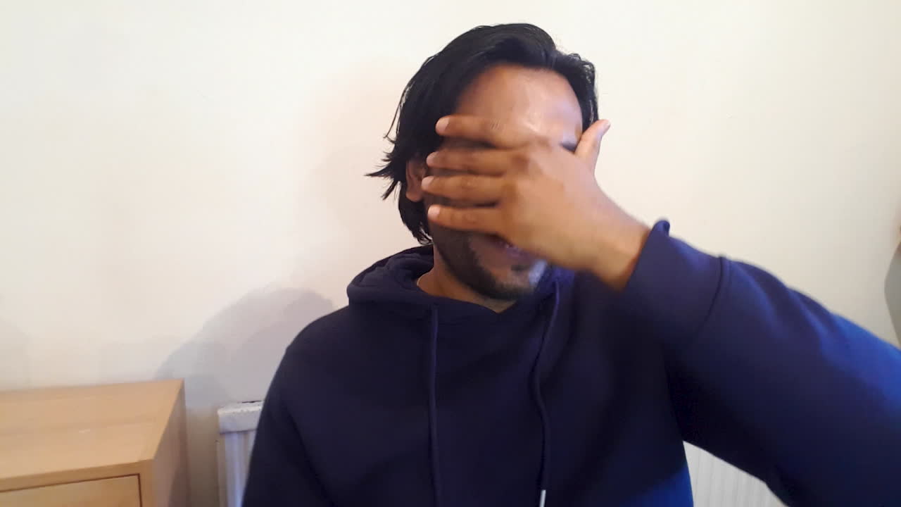 화상 통화를 하는 청년이 친구의 이야기를 듣고 반응하는 모습