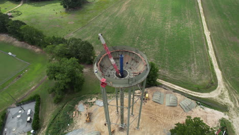 epic fly over rotating drone shot of a water tower under construction