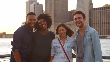 two friendly young couples laugh by the river in manhattan