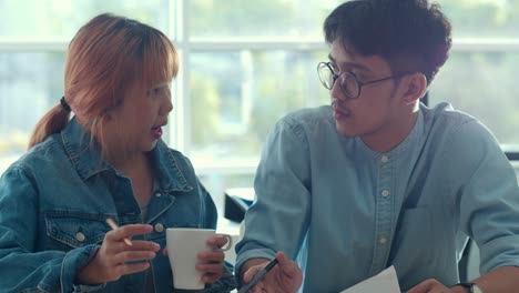 young asian creative team meeting working on laptop. group of professional business man and woman drink coffee , discuss and thinking new idea, business situation, teamwork in modern office concept.