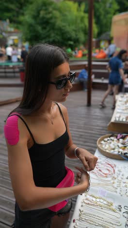 woman shopping for jewelry at an outdoor market