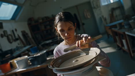 woman working on a pottery wheel in a ceramics workshop