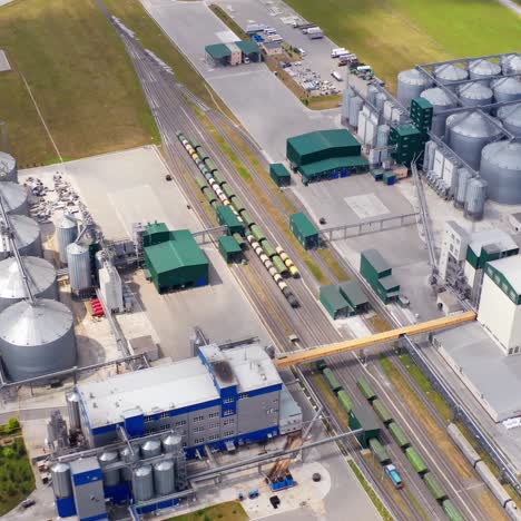 contemporary agriculture complex. view from above on industry with large storage bins for keeping crop. freight trains and grain elevators on field. top view