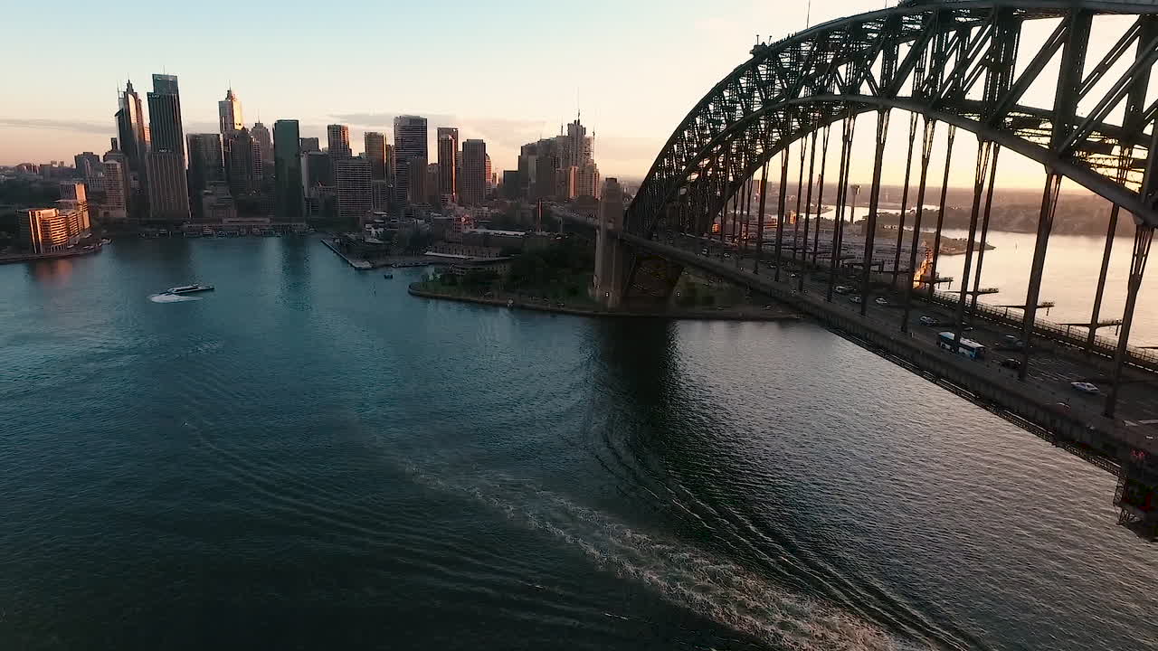 Aerial Pan And Tilt Towards Sydney Harbour Bridge At Sunset, City in Background