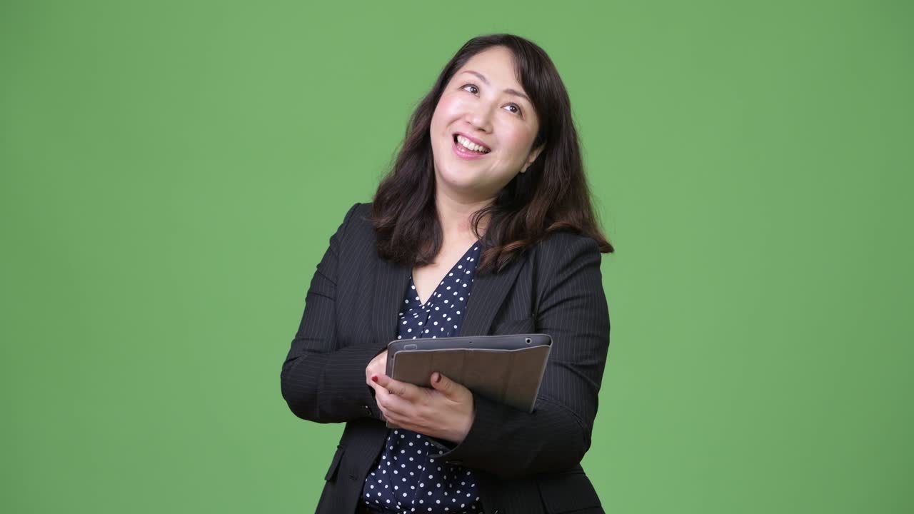 Mature beautiful Asian businesswoman using digital tablet