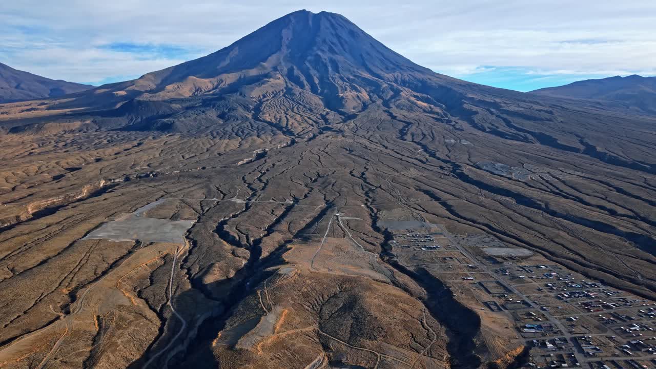 Uma tomada cinematográfica panorâmica com drone do vulcão Misti perto de Arequipa, no Peru, com vastos fluxos de lava brilhando na luz dourada do nascer do sol, revelando a enorme escala do antigo escoamento vulcânico