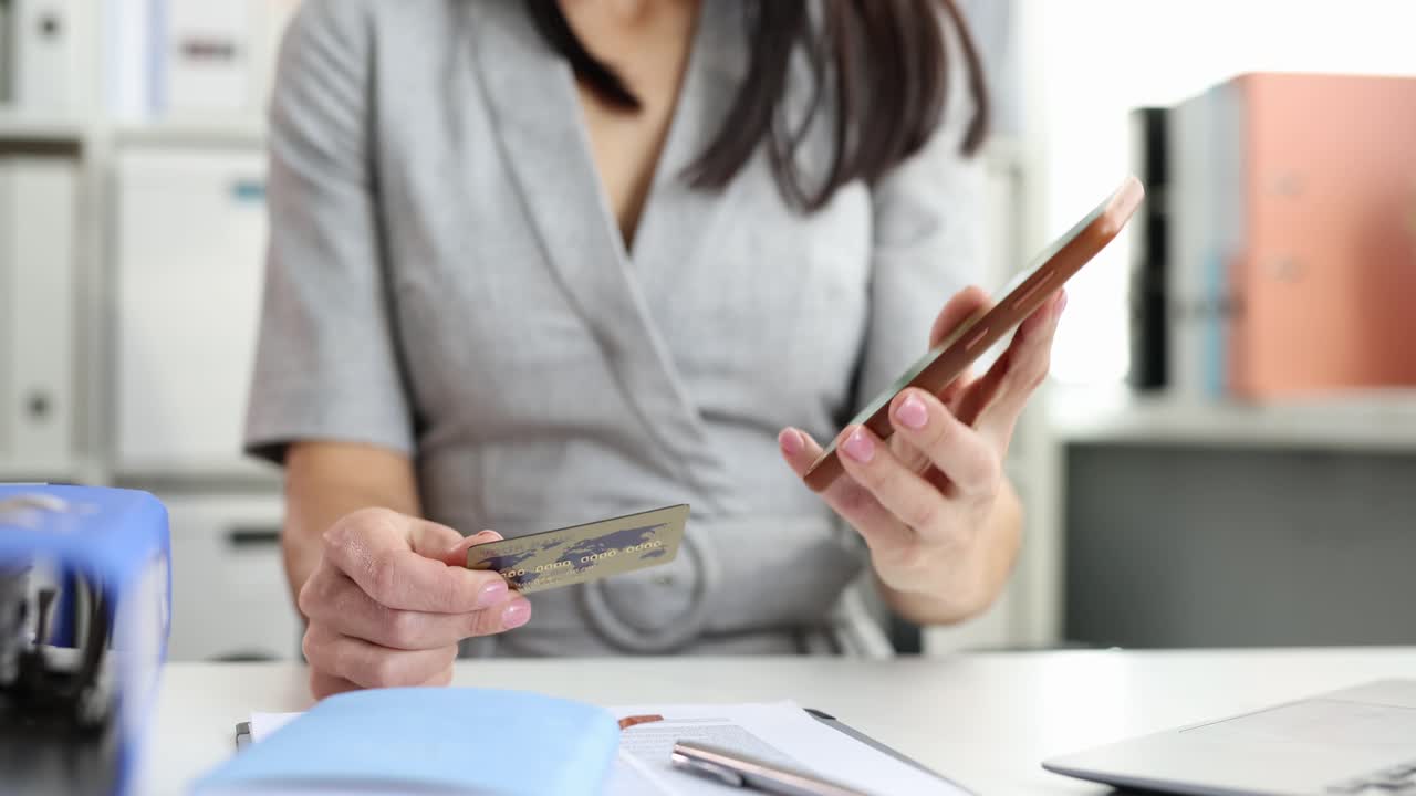 Donna che avvicina la carta di credito al telefono cellulare ed effettua un pagamento film in 4k