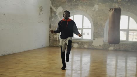 Hombre-Afroamericano-Saltando-La-Cuerda-En-Una-Sala-Vacía,-Escucha-Música