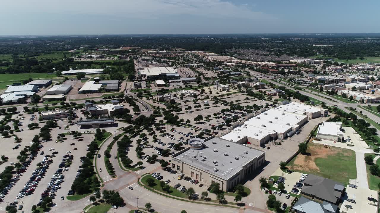 Aerial video of The Marketplace at Highland Village in Highland Village Texas.  Businesses and parking lot can be seen.  Located on the east side of Long Prairie Rd.