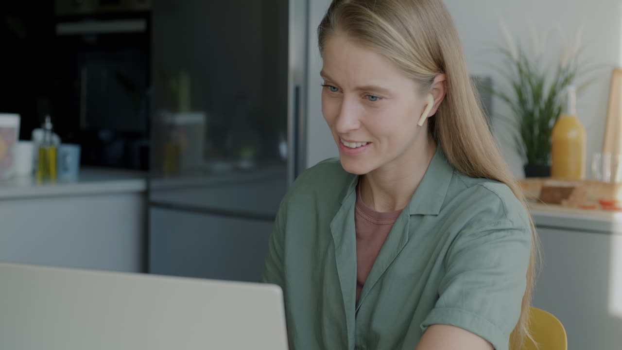 Kvinde på videoopkald i sit køkken