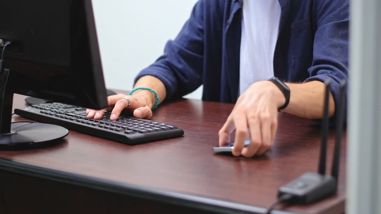 Working young man irritated by the notifications from his mobile phone. Office daily life situations