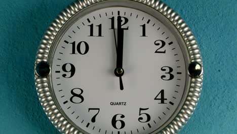 el reloj de pared de cuarzo con la manija de segundo funciona en el sentido de las agujas del reloj. el reloj muestra las doce.