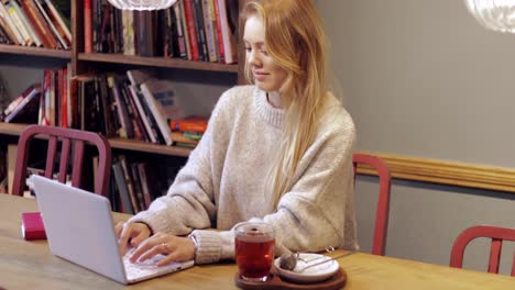 Attraktive-Frau-Mit-Laptop-In-Bibliothek