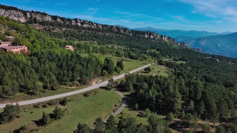 red car stopped at intersection of two roads in middle of the mountains, catalonia