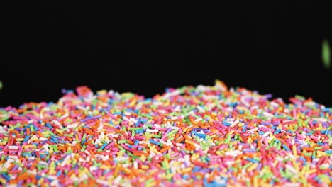 rainbow sprinkles cascade onto a pile