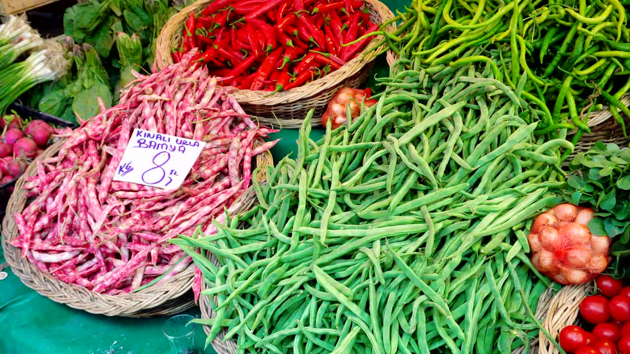 Fresh vegetables - red tomatoes, green peppers - for sale in a market.