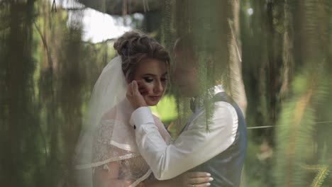 a beautiful bride and groom stand together in a romantic outdoor setting.