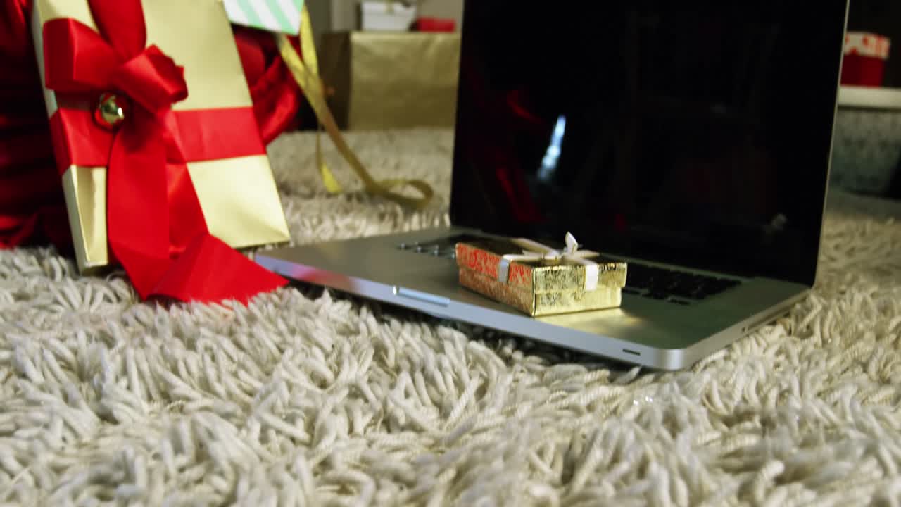 primer plano de cajas de regalos y computadora portátil en la alfombra