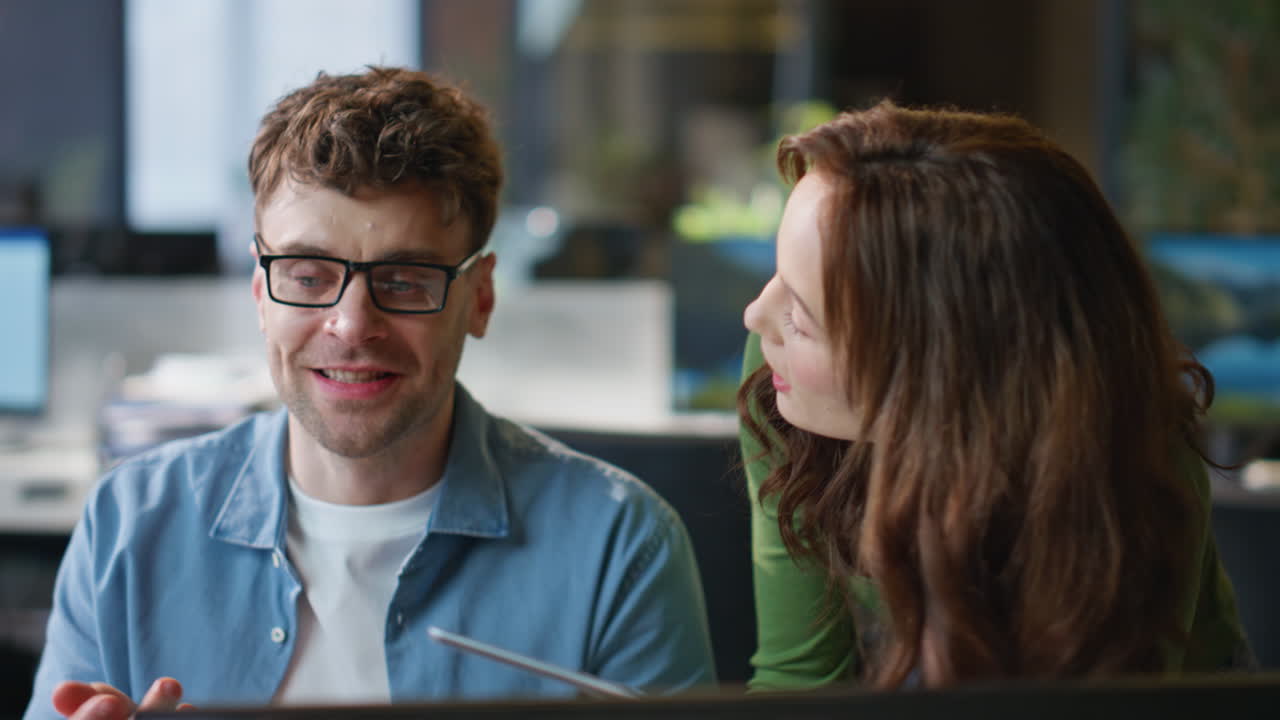 Couple colleagues discussing ideas interacting together in modern office closeup