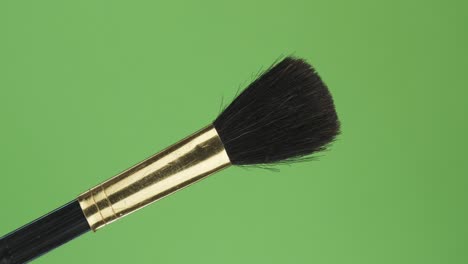 diagonal rotation of the makeup brush. isolated on green.