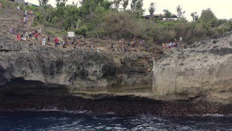 Una-Trinchera-Con-Agua-Quieta-Dentro-De-La-Costa-De-Playa-Rota-Con-Turistas-Tomando-Fotos-A-Sus-Lados,-Nusa-Penida,-Bali,-Indonesia