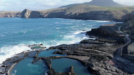 aerial shot of the natural rock pools of the port of agaete where the sea breaks with force