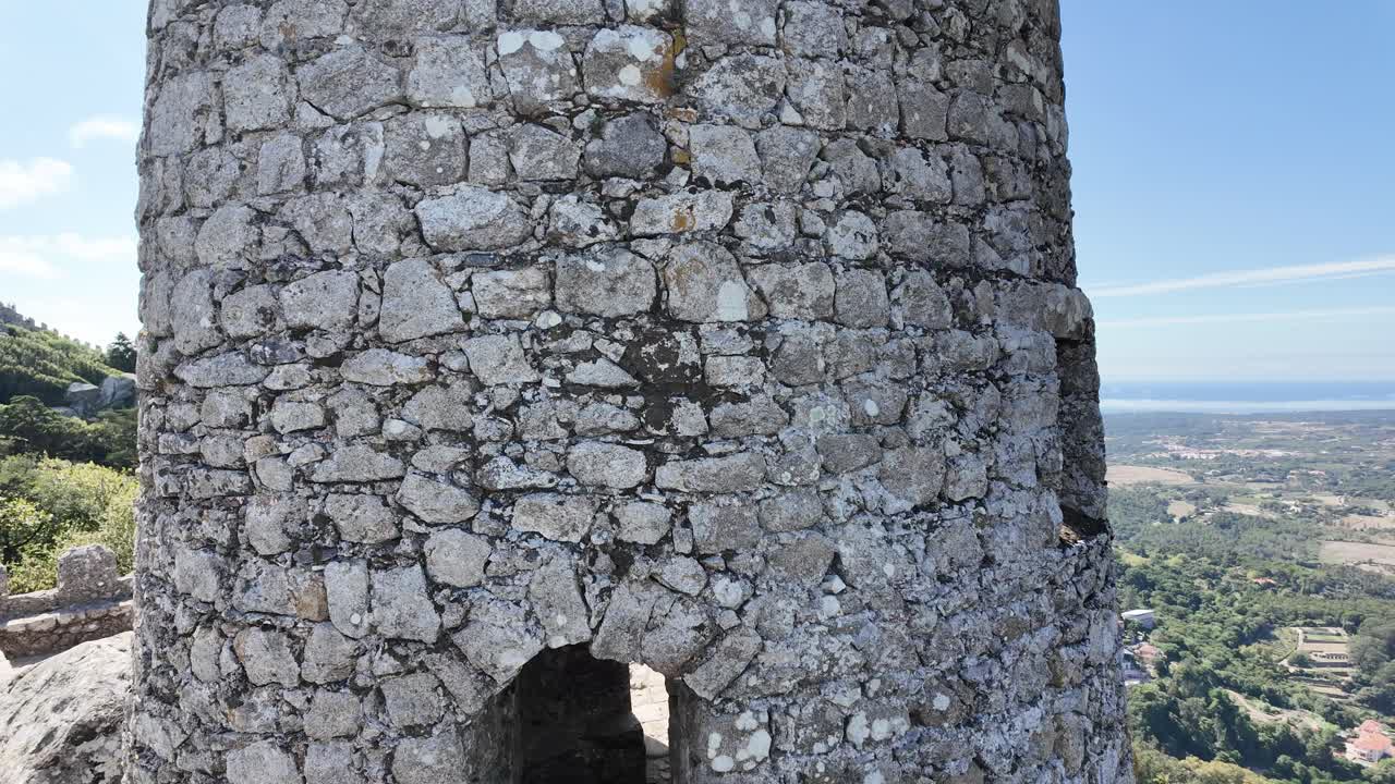 The moorish castle in sintra surrounded by lush landscape on a clear day, aerial view