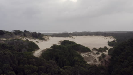 aerial: drone flying towards a sand dune near strahan, tasmania australia