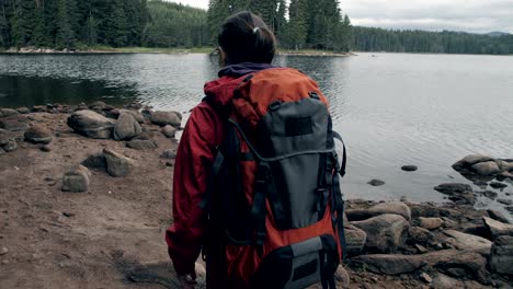 slow motion of a young tourist woman passing by a lake.