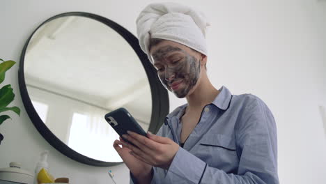 Female-With-Facial-Mask-Using-A-Smartphone