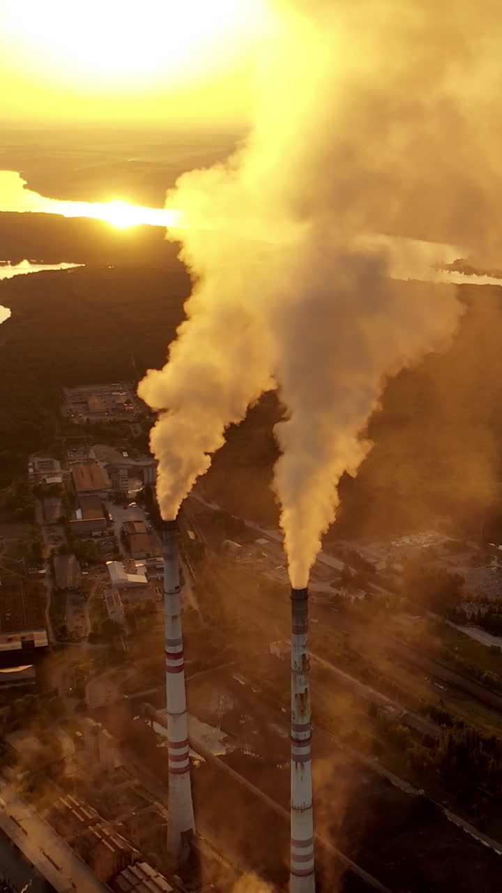Smoking industrial pipes. Aerial view of old factory with pipes Vertical video