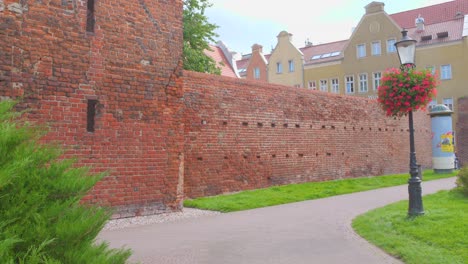 historic red brick wall and colorful buildings in gdansk's old town during a calm day