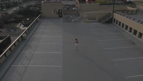 Wide-drone-pull-away-from-dancer-on-a-parkade-roof