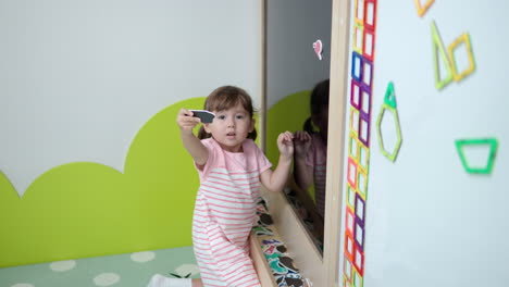 Entzückende-3-jährige-Mädchen-Kleinkind-Stick-Magnetkarten-Mit-Tieren-Auf-Magnetischer-Tafel-Im-Spielzimmer-–-Frühe-Bildung-Und-Entwicklung-Von-Kindern-Auf-Spielerische-Art-Und-Weise