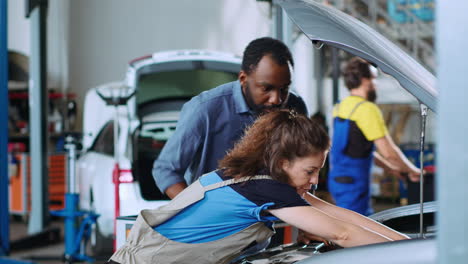 mechanic in garage changes car motor oil