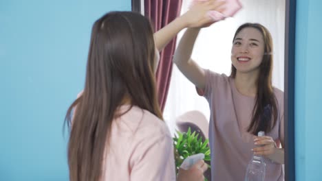 cheerful asian young woman having fun cleaning.