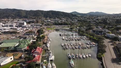 nice aerial pull back of whangarei city, victoria canopy bridge, town basin marina village, museum and whangarei marina on riverfront of hatea river