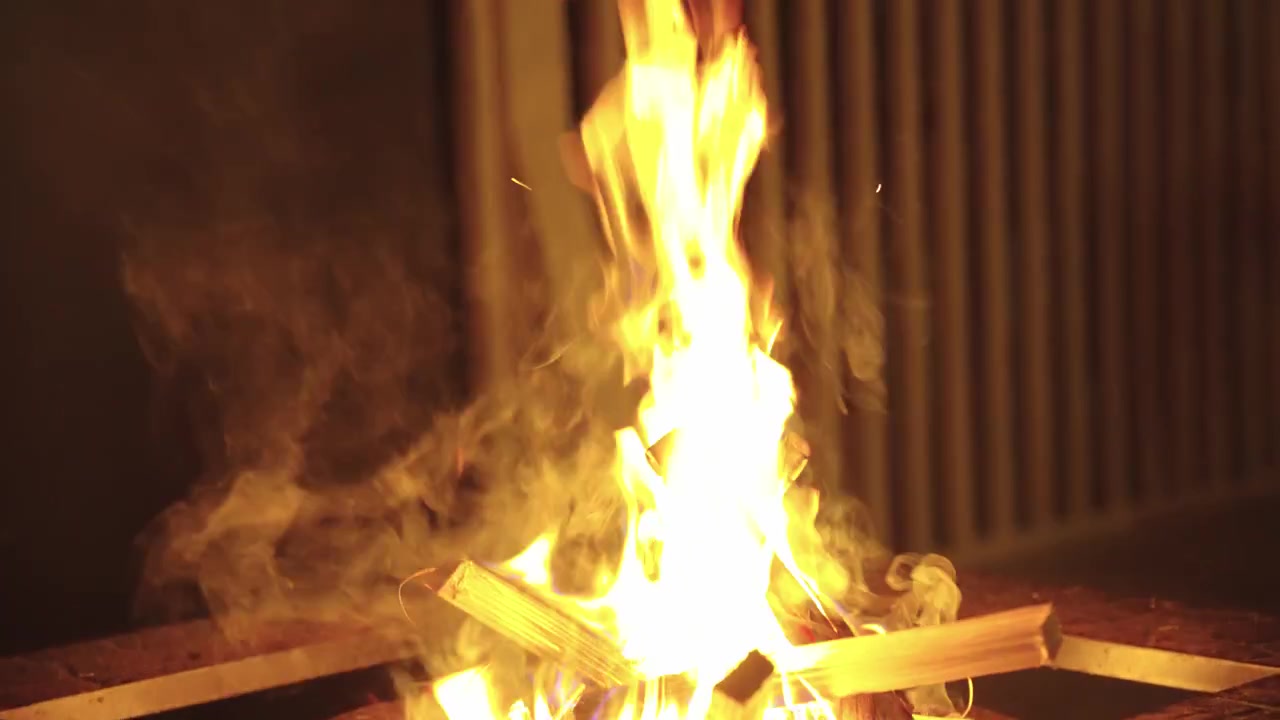 Lagerfeuer brennt in der Nacht, dunkle Szene mit Blick zum dunklen Himmel.