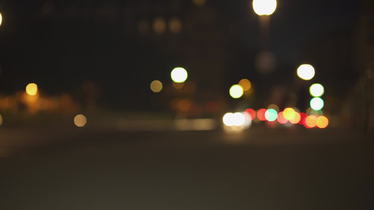 luces nocturnas desfocalizadas de la ciudad cerca de la torre eiffel en parís. color borroso bokeh de coches en movimiento y autobús en la calle. disparo estático 4k uhd. llamaradas de lente, disparo ancho.